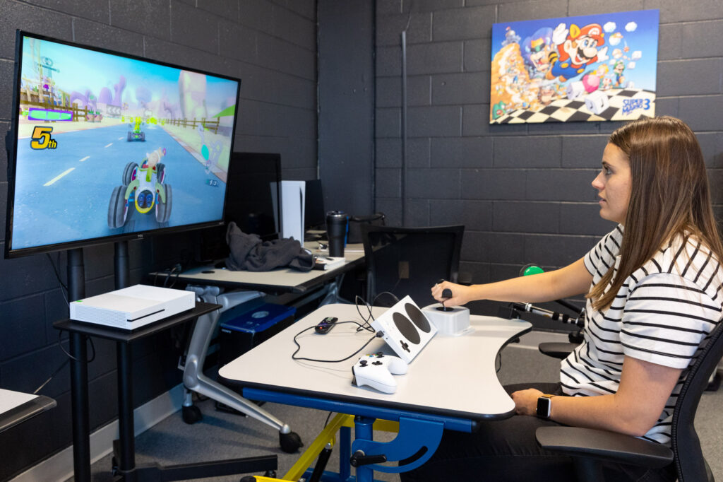 Patient in striped shirt participating/using adaptive gaming technology