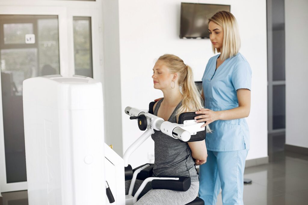 Woman at physiotherapy making physical exercises with qualified therapist